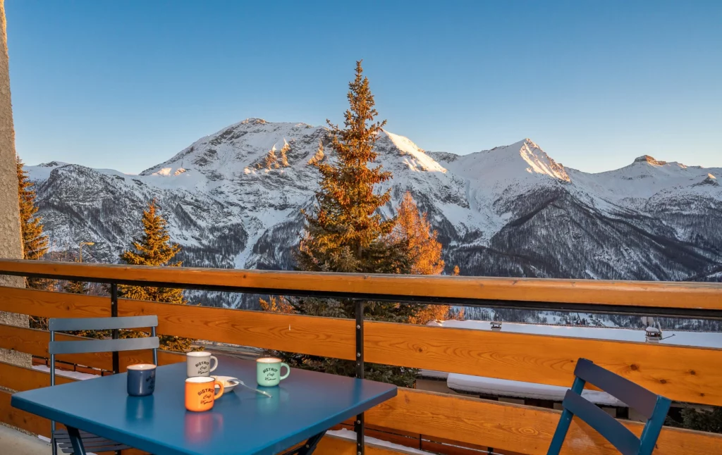 Vue depuis le balcon de l'appartement Horizon 1800 à Orcières Merlette en hiver et son mobilier pour prendre le café ou déjeuner.