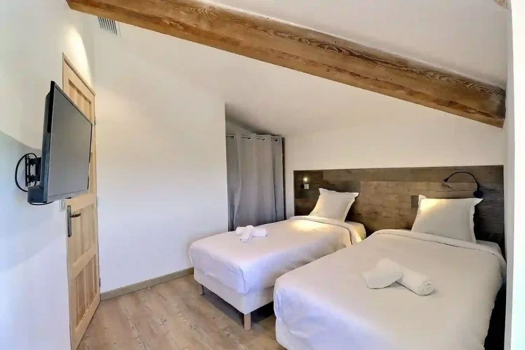 Chambre moderne du Gîte Le Figuier à Gras, deux lits simples avec TV connectée.