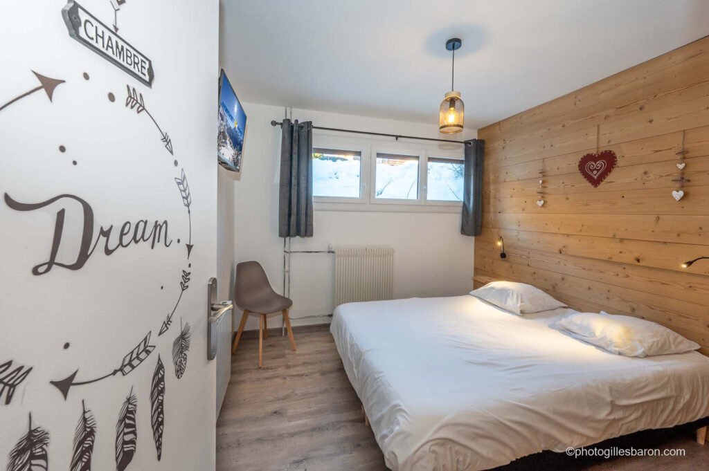 Chambre lumineuse avec lit double équipée TV connectée et murs bois de l'appartement Horizon 1800 à Orcières