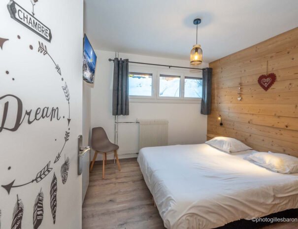 Chambre lumineuse avec lit double équipée TV connectée et murs bois de l'appartement Horizon 1800 à Orcières